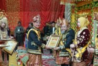 Gubernur Bengkulu Helmi Hasan, saat dianugerahi gelar adat oleh Ketua Badan Musyawarah Adat Provinsi Bengkulu, S. Effendi, melalui Sidang Mufakat Rajo Penghulu di Balai Raya Semarak, Senin (17/11). (foto: dok Pemprov Bengkulu)